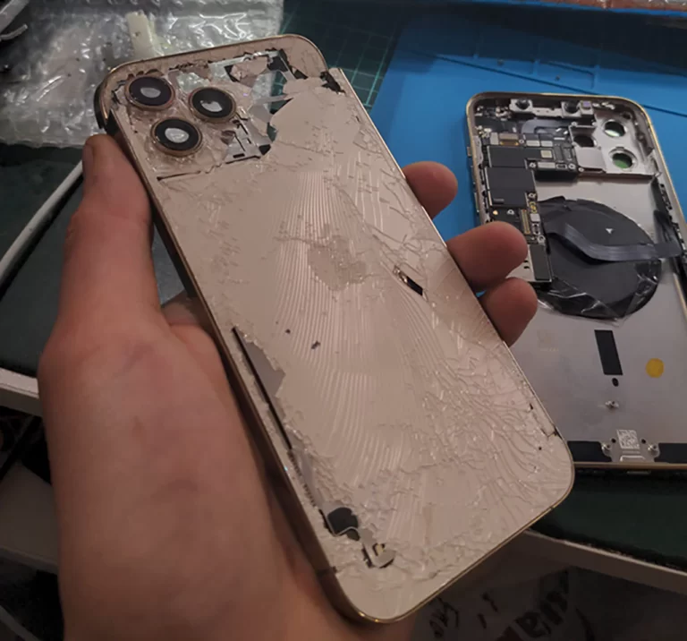 Buzztime Electronics holding a smashed iPhone 12 Pro Max