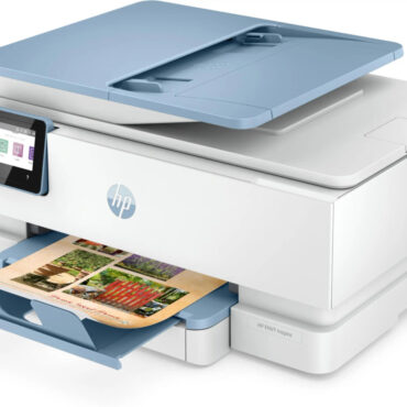 An HP Envy Inspire 7920e printer. The printer is a sleek, modern design with a white and gray color scheme. It features a flatbed scanner copier and a photo-quality printer.